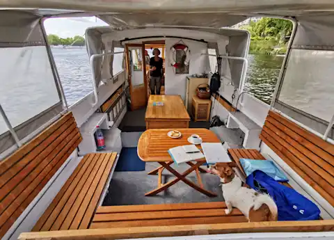 Seating area and cabin of the party boat ​​Miss Choy with wooden benches and table