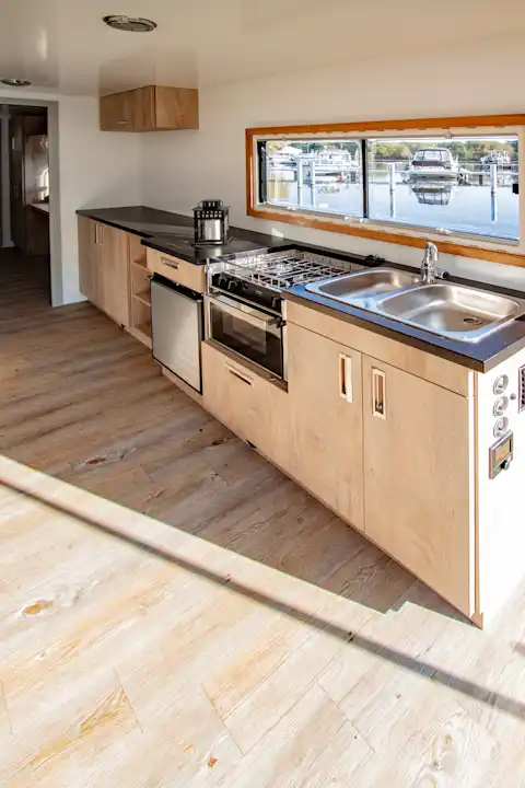 Große Küchenzeile und Holzfußboden auf dem Hausboot Flexmobil in Berlin