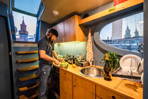 Man cooks in the kitchen of the Rossi houseboat